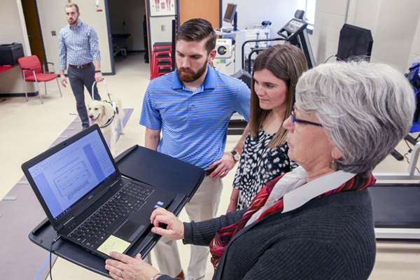 From left, graduate students Tommy Otley (shown walking dog), Mitchell Aarons and Erin McCarthy have been working with associate professor of physical therapy Dr. Sue Ann Kalish on guide dog research.